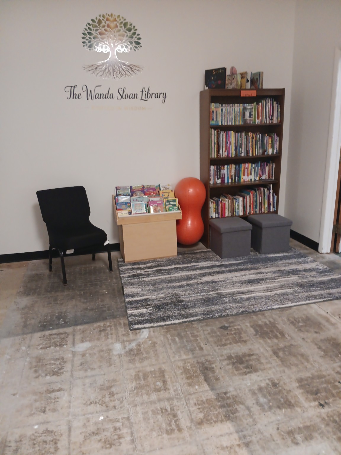 Books, seating, and the tree emblem in the Wanda Sloan Library at DWCOH